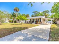 Charming single-story home with a well-manicured lawn, covered parking, and beautiful landscaping at 2605 Fairmont Ave, New Smyrna Beach, FL 32168