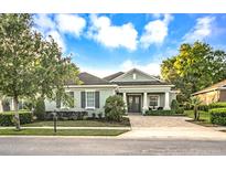 Charming single-story home with manicured landscaping, brick driveway, and a welcoming front entrance at 302 Lamberton Ln, Deland, FL 32724