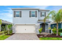 Charming two-story home with a two car garage, stone accents, and lush landscaping at 3120 Areca Ave, New Smyrna Beach, FL 32168