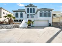 Stunning exterior of a two-story home featuring a two-car garage, complemented by lush tropical landscaping at 4363 S Atlantic Ave, Ponce Inlet, FL 32127