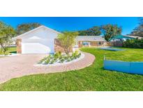 Charming brick home featuring a two-car garage and a meticulously maintained front yard with beautiful landscaping at 4745 Dixie Dr, Ponce Inlet, FL 32127
