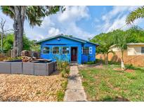 Charming blue single-story home with a well-manicured front yard, walkway, and patio area at 600 Holmes Ave, Daytona Beach, FL 32114
