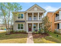 Charming two-story home with a quaint front porch and a beautifully landscaped yard at 8561 Randal Park Blvd, Orlando, FL 32832