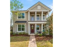 Charming two-story home with a landscaped front yard, welcoming porch, and neutral-colored exterior at 8561 Randal Park Blvd, Orlando, FL 32832