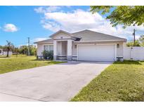 Charming single-story home with a well-maintained lawn and a two-car garage on a sunny day at 999 Trumbull St, Deltona, FL 32725