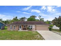 Charming single-story brick home featuring a well-maintained lawn and attached two-car garage at 1054 Abeline Dr, Deltona, FL 32725