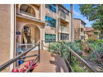 Inviting condo building featuring a wooden walkway and lush tropical landscaping at 1401 S Palmetto Ave # 300, Daytona Beach, FL 32114