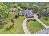 Stunning aerial view of a home featuring lush landscaping, a circular driveway, and a well-maintained lawn at 1661 Timber Hills Dr, Deland, FL 32724