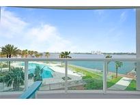 Beautiful balcony view overlooking a sparkling pool and waterfront with swaying palm trees on a sunny day at 241 Riverside Dr # 304, Daytona Beach, FL 32117