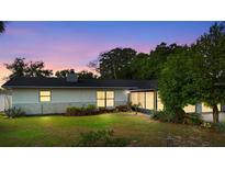 A cozy single-story home with a well-maintained lawn and mature trees in a quiet neighborhood at 265 S Fairbairn Dr, Deltona, FL 32725