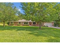 Charming brick home featuring a well-manicured lawn and mature trees at 349 Evansdale Rd, Lake Mary, FL 32746