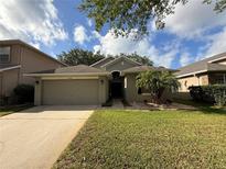 Charming single-story home with a well-manicured lawn, two-car garage and mature landscaping at 5548 Burlwood Dr, Orlando, FL 32810