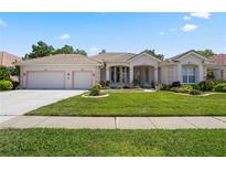 Charming home featuring a well-manicured lawn, two-car garage, and stylish exterior trim accents at 6111 Oxbow Bend Ln, Port Orange, FL 32128