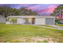 Charming single-story home featuring a well-manicured lawn and attached garage at 1044 Deltona Blvd, Deltona, FL 32725