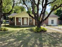 Charming brick home featuring a well-manicured lawn and mature landscaping at 111 S Delaware Ave, Deland, FL 32720