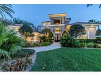 Stunning home exterior with lush landscaping, manicured lawn, and an elegant entryway with custom wrought iron doors at 1117 Oxbridge Ln, Ormond Beach, FL 32174