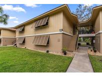 Condo exterior featuring shuttered windows and well-maintained landscaping, offering curb appeal and a welcoming facade at 140 Orchid Woods Ct # 14B, Deltona, FL 32725