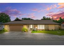 Charming single-story home featuring stone accents, a well-manicured lawn, and an attached two-car garage at 1426 Saxon Blvd, Deltona, FL 32725