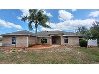 Charming brick home with a well-manicured front yard and inviting entryway at 1491 E Palomar Dr, Deltona, FL 32738