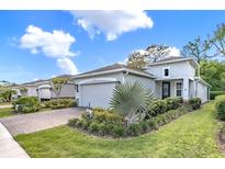 Beautiful single-Gathering home featuring a well-maintained lawn, a paver driveway, and an attached two-car garage at 173 Old Moss Cir, Deland, FL 32724