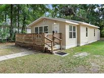Charming single-story home with a wooden porch and landscaped front yard at 211 S Delaware Ave, Deland, FL 32720