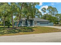 Charming single-story home featuring a well-maintained lawn, blue paint, and a two-car garage at 2150 Deck Ct, Deltona, FL 32738