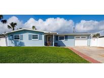 Charming single-story home with a lush green lawn and a classic blue exterior at 2573 W Coral Way, Daytona Beach, FL 32118