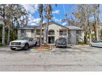 Condominium building featuring multiple units, mature landscaping, and ample parking on a sunny day at 2706 Oak Trail Run # 6, Port Orange, FL 32127