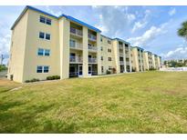 Spacious condominium with white balconies and a blue roof, surrounded by lush green grass at 3131 S Ridgewood Ave # 4120, Daytona Beach, FL 32119