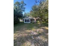 Charming single-story home featuring a quaint front yard and mature trees at 328 W Connecticut Ave, Lake Helen, FL 32744