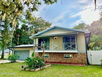Charming home with a stone foundation, front balcony, and well-maintained landscaping at 370 S Center St, Ormond Beach, FL 32174