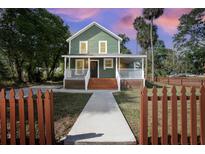 Charming two-story home features a welcoming front porch and a well-maintained yard with a picket fence at 415 W Church St, Deland, FL 32720
