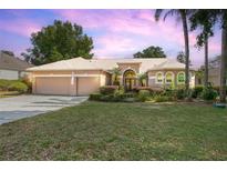 Charming single-story home with a well-manicured lawn, beautiful landscaping, and a two-car garage at 484 Lanarkshire Pl, Apopka, FL 32712