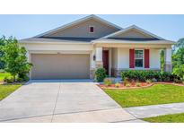 Charming single-story home featuring a well-manicured lawn and a two car garage at 5064 Meadow Song Dr, Okahumpka, FL 34762