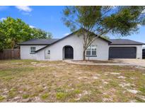 Charming single-story home with stucco exterior, arched entry, and attached two-car garage at 1202 Anderson St, Deltona, FL 32725