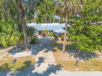 Charming single-story home featuring a metal roof, mature landscaping, and a spacious driveway at 1927 Orange Tree Dr, Edgewater, FL 32141