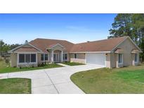 Spacious single-story home boasts a concrete driveway, attached garage, and well-maintained lawn at 2048 Laredo Dr, Deltona, FL 32738