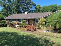 Charming brick home with a meticulously landscaped front yard, lush greenery, and welcoming facade at 2427 Beck Cir, Deltona, FL 32738