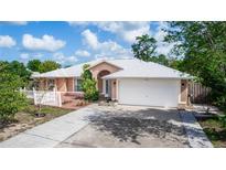 Charming single-story home with well-maintained landscaping, a brick walkway, and a two-car garage at 2466 Candlewick St, Deltona, FL 32738
