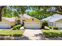 Charming yellow single-story home with a two-car garage, mature landscaping, and a well-manicured lawn at 3140 Kailani Ct, Ormond Beach, FL 32174