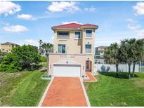 Inviting two-story home with a red tile roof, manicured lawn, and a driveway leading to an attached garage at 3817 Islamorada Dr, Ormond Beach, FL 32176