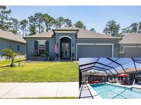 Beautiful single-Gathering home features a two-car garage, lawn, flowerbeds, and a screened-in pool at 6006 Mount Zion Cir, Deland, FL 32724
