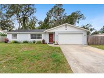 Charming single-story home showcasing well-maintained landscaping and a classic red door at 732 Mockingbird Ln, Deland, FL 32720