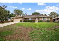 Charming single-story brick home featuring an attached garage and a well-maintained lawn with mature landscaping at 808 Jutland St, Deltona, FL 32725