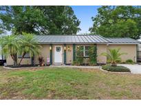 Charming home with a well-manicured lawn, palm tree, and decorative accents by the front door at 1135 5Th St, Orange City, FL 32763