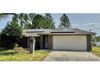 Charming single-story brick home featuring a two-car garage and solar panels at 1649 Courtland Blvd, Deltona, FL 32738