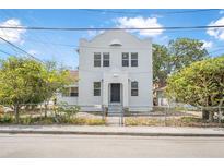 Bright two-story stucco home featuring a gated front yard and a sturdy, classic architectural design at 216 Earl St, Daytona Beach, FL 32118