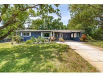 Charming home with a well-manicured lawn, lush landscaping, and a convenient carport at 220 Buena Vista St, Debary, FL 32713