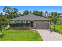 Charming single-story home featuring a brick driveway, well-maintained lawn, and a welcoming front entrance at 2337 Oxmoor Dr, Deland, FL 32724