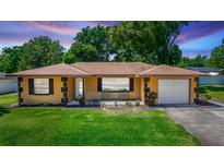 Charming single-story home featuring well-manicured lawn and neat, appealing landscaping at 242 Linda Vista St, Debary, FL 32713